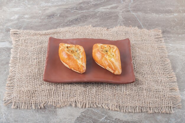 Small pide portions served on a platter on marble surface