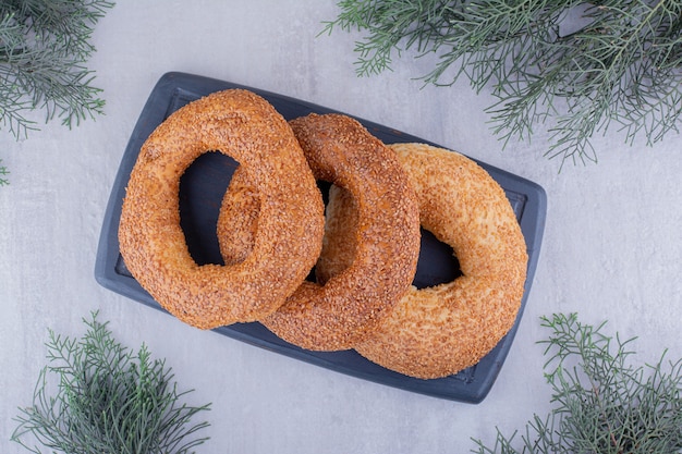 Foto gratuita piccolo mucchio di bagel su un bordo della marina su sfondo bianco.