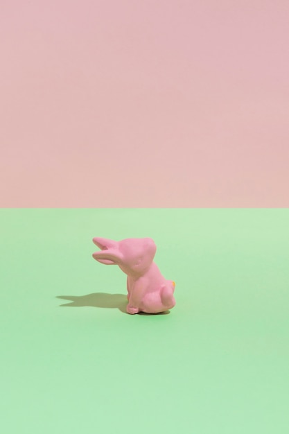 Small pink toy rabbit on green table