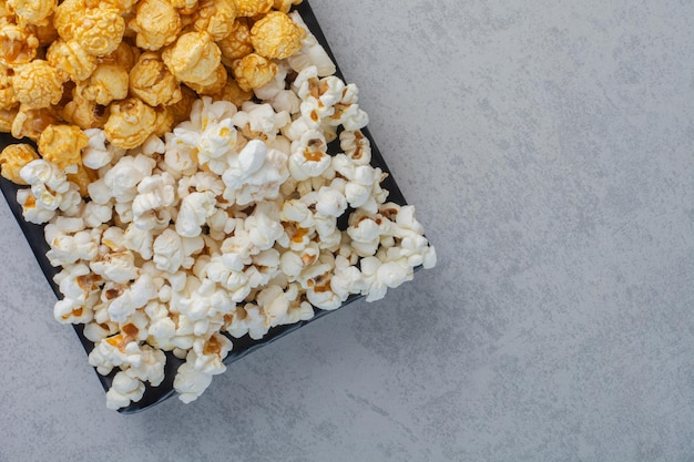 Small platter of popcorn candy and salty popcorn on marble surface