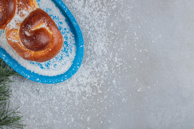 Small platter with a sweet bun on marble table.