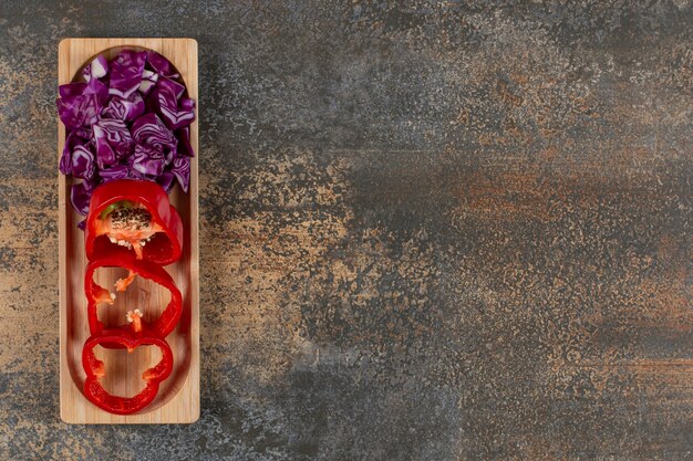 A small portion finely chopped cabbage and sliced pepper , on the marble surface