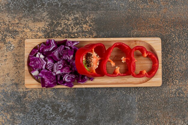 A small portion finely chopped cabbage and sliced pepper , on the marble surface