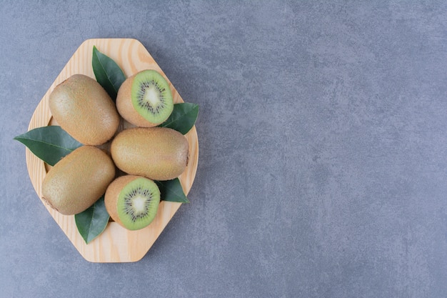 Free photo a small portion kiwi fruits on marble table.