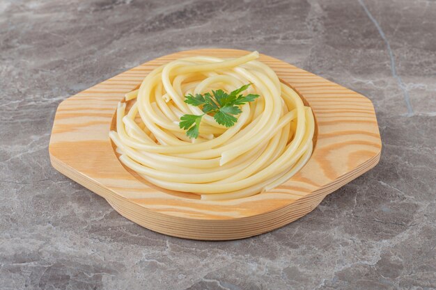 A small portion spaghetti , on the marble surface.