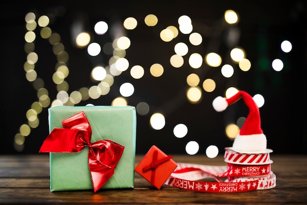 Foto gratuita piccoli regali vicino a nastri e cappello natalizio