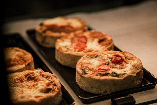 small puff pies with vegetables and meat quiches in a cafe window