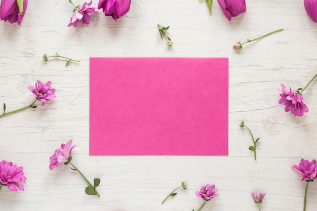 Free photo small purple flowers with paper on table