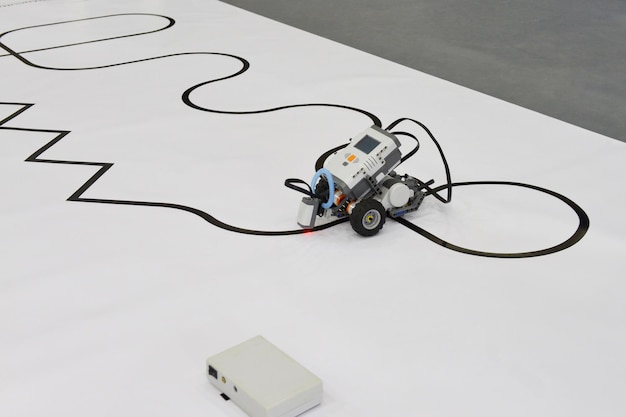 塗装された道路を運転する小型ロボット。電子機械または車の手作りモデルデザイン。 it車両のモデリングとプログラミング