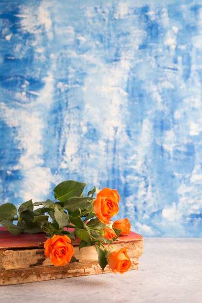 Small roses and old book on blue background