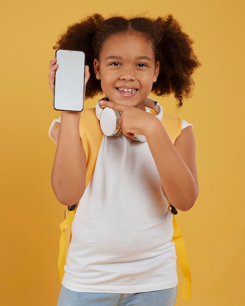 空の携帯電話を見せている小さな女子高生