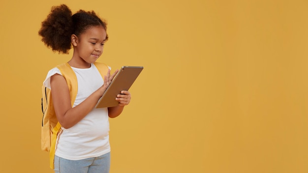 Free photo small school girl using a digital tablet