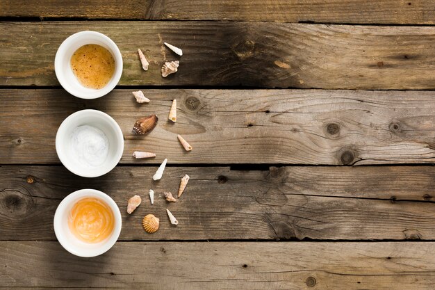 Small seashell and spa ingredient on rusty wooden table