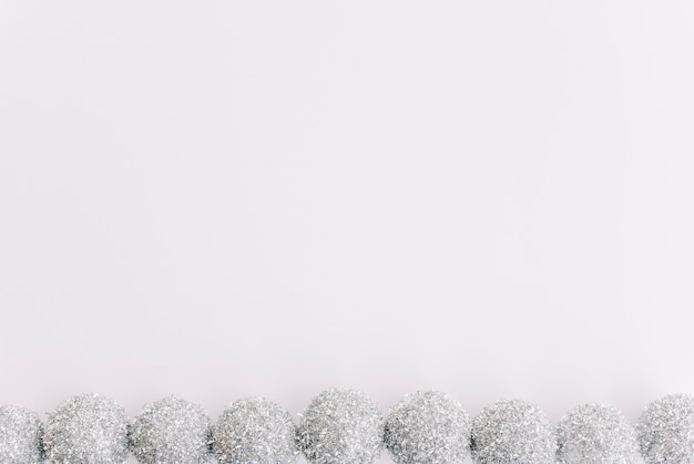 Small silver baubles on white table