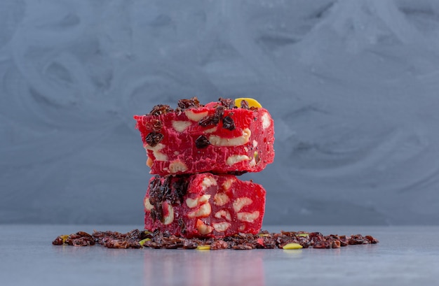 A small stack of Turkish delights and raisins on marble background.