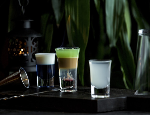 Small tiny glasses of variety of drinks in bar stand