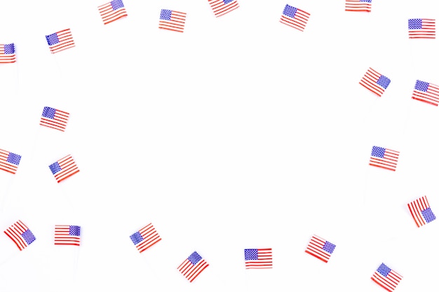 Маленькие флаги США разбросаны на белом фоне