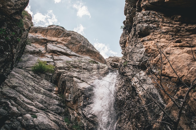 Small waterfall in the rocky mountains shot from below