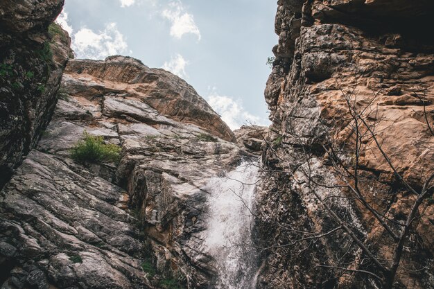 Небольшой водопад в скалистых горах снят снизу