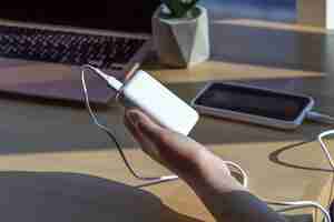 Free photo small white power bank in a womans hand