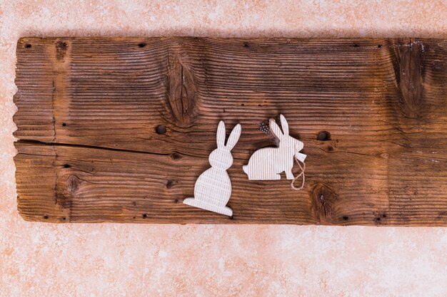 Small white rabbits on wooden board