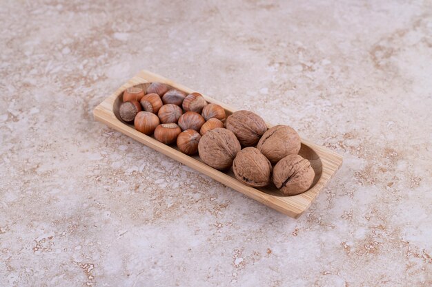 A small wooden board full of healthy walnuts.