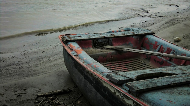 イタリアの川のほとりに捨てられた時間と天候によって破壊され、身に着けられた小さな木製のボート。