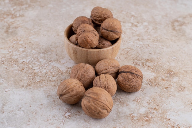 A small wooden bowl full of healthy walnuts.