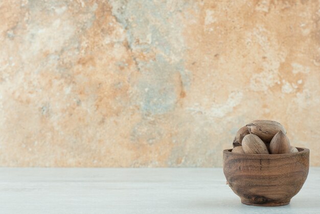 A small wooden bowl of nuts on white background. High quality photo