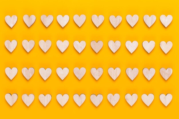 Маленькие деревянные сердечки на желтом фоне креативная идея открытка на день святого валентина
