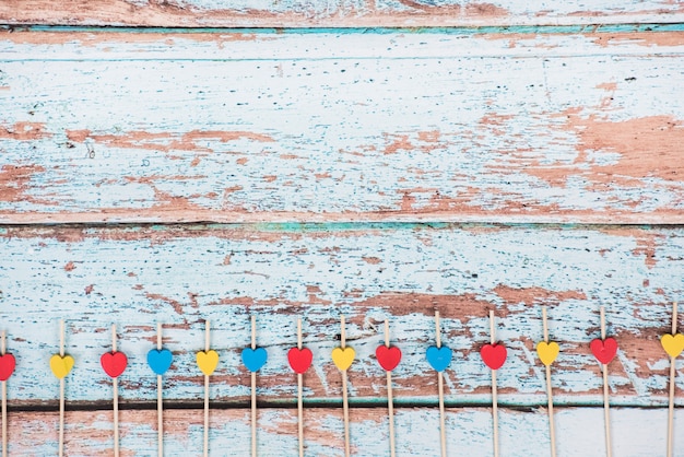 Small wooden hearts on sticks on table