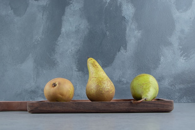 Free photo a small wooden tray with pears on marble