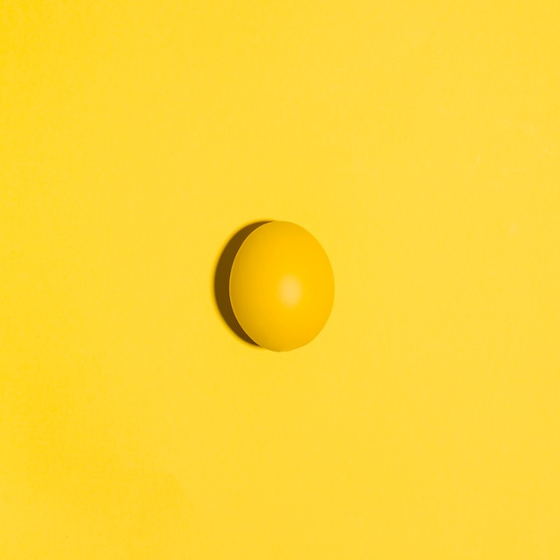 Free photo small yellow easter egg on yellow table