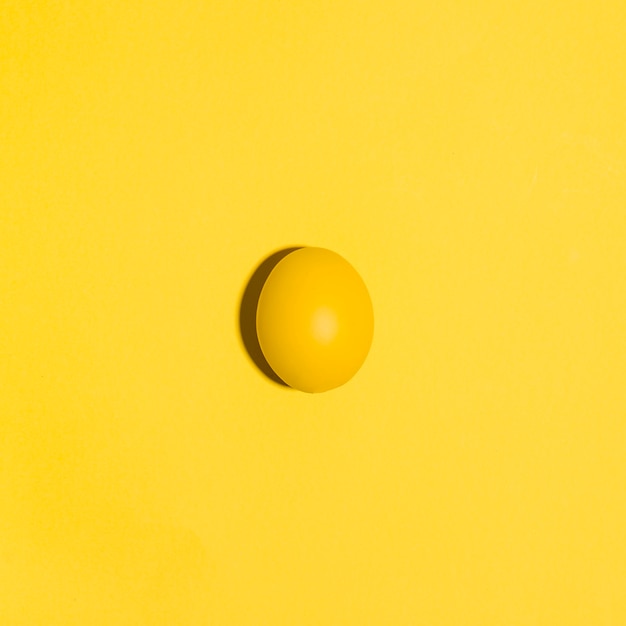 黄色のテーブルの上の小さな黄色のイースターエッグ