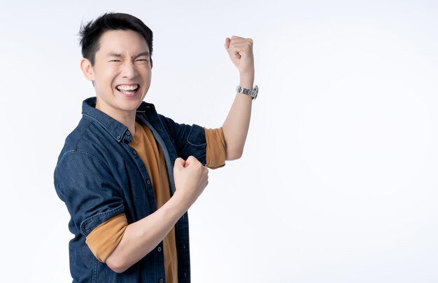 Smart attractive asian friendly male hand rise up cheerful exited standing and smile with freshness and joyful casual blue shirt portrait white background