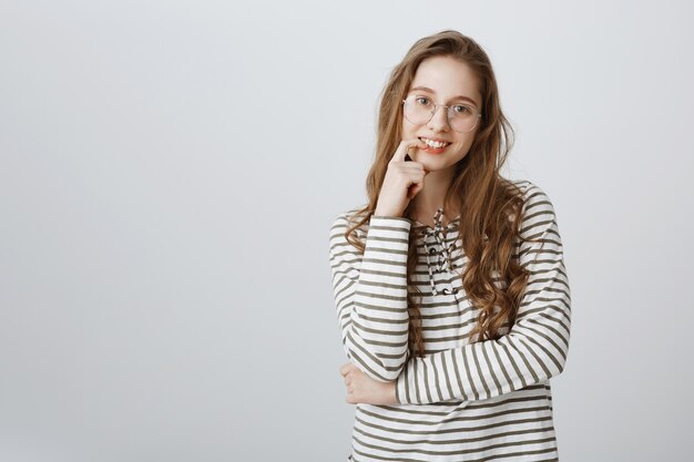 Smart college girl in glasses smiling pleased, have idea