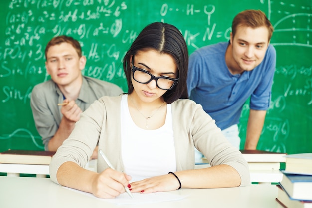 Smart girl working concentrated with classmates
