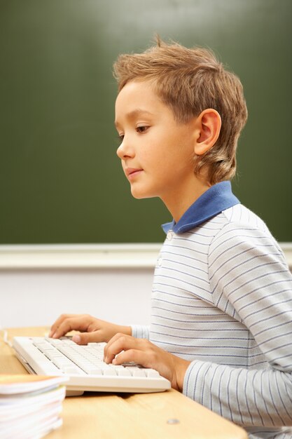 Smart little boy having computer class