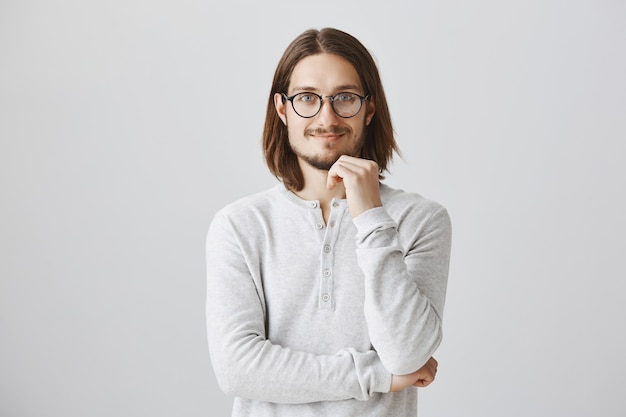 Smart smiling man in glasses listening with interest