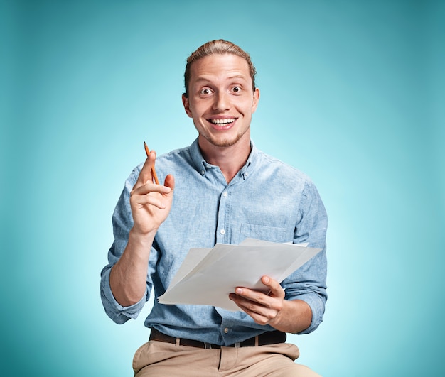 Free photo smart smiling student with great idea holding sheets of paper