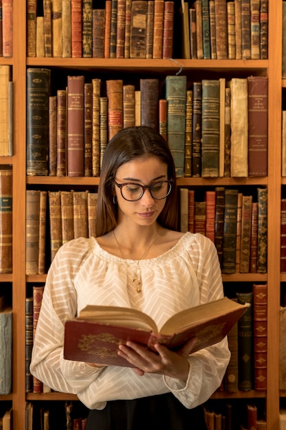 Smart woman reading book in library