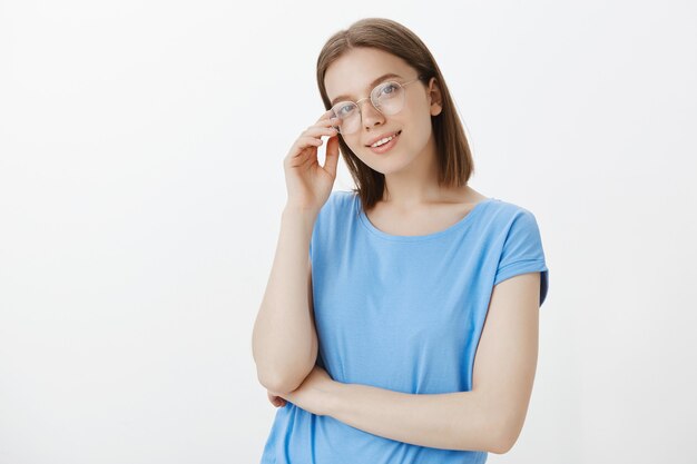Smart young woman in glasses smiling pleased