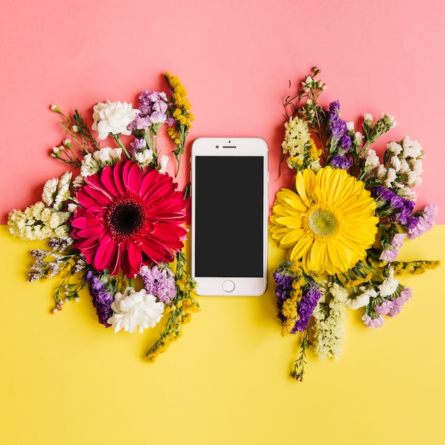 Бесплатное фото Смартфон и цветы