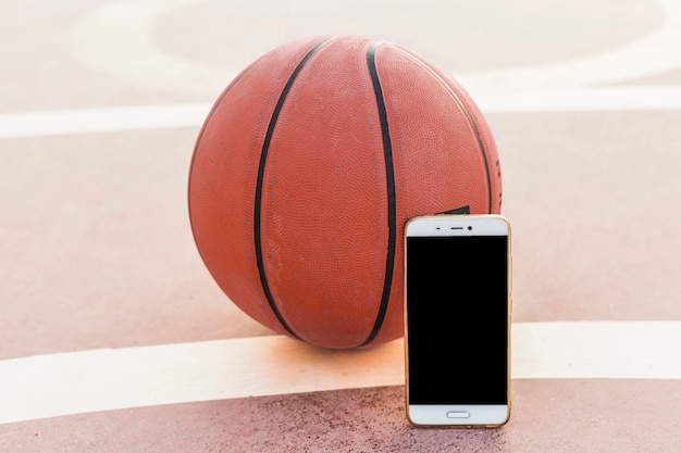 Free photo smartphone and basketball in court