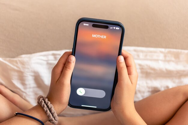 smartphone in child hands with incoming mother call on a screen