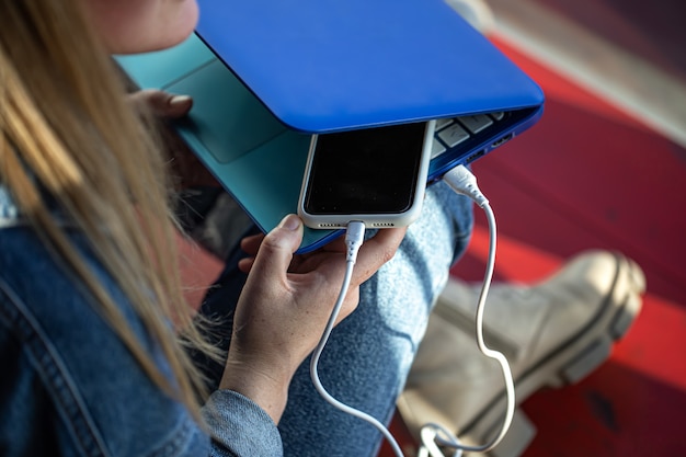 A smartphone connected to a laptop using a USB cable, phone charging, data exchange.