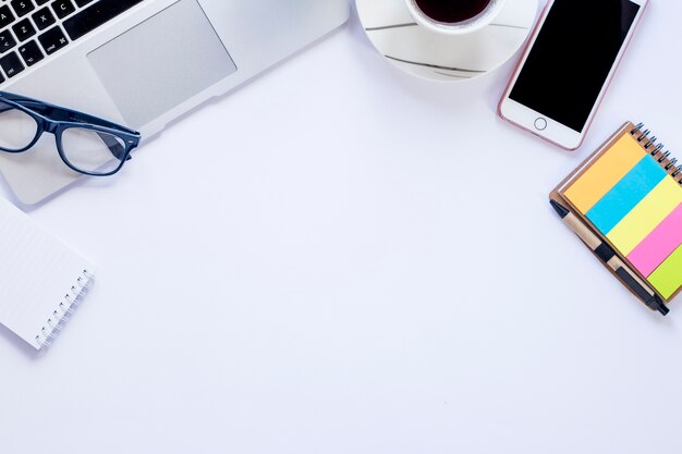 Smartphone and cup near laptop