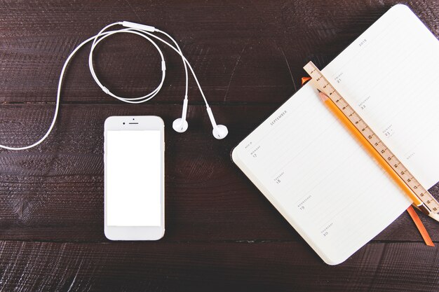 Smartphone and earphones near stationery