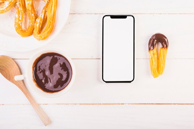 Смартфон на кухонном столе с десертом