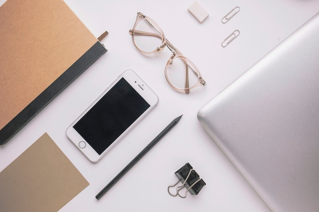 Smartphone and laptop amidst stationery